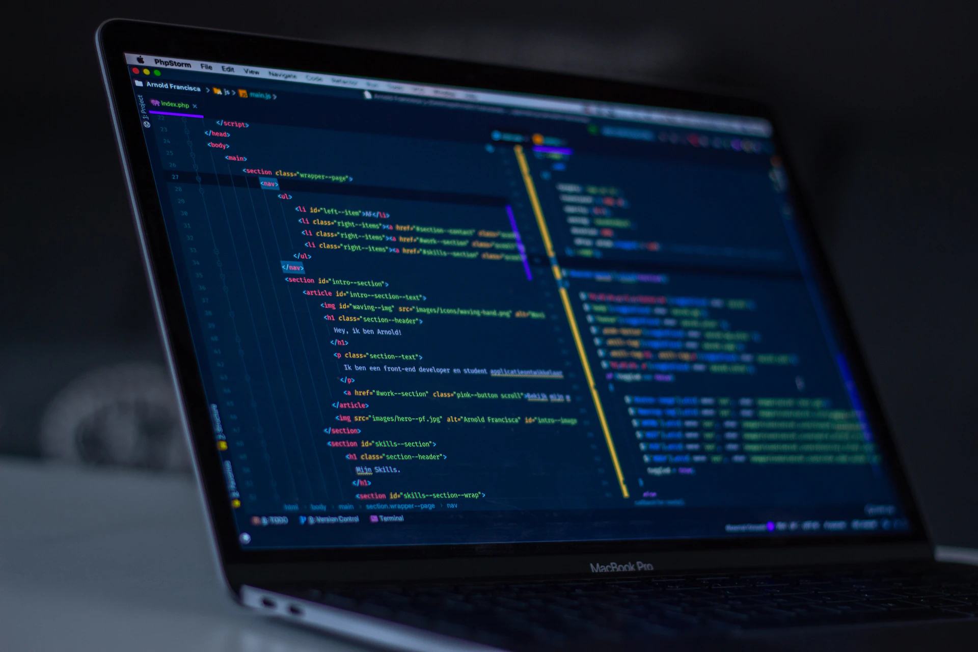 A laptop showing code in a dark room